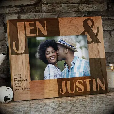 Personalized wooden photo frame displays a photo of a couple kissing. 