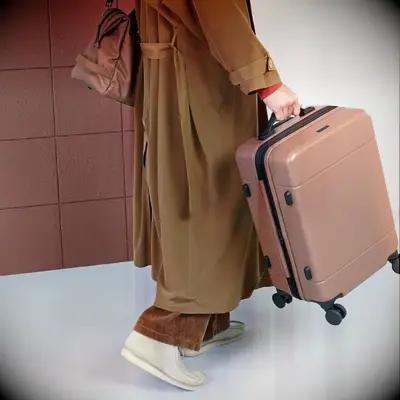 Woman holding a stylish carry on suitcase from CALPAK