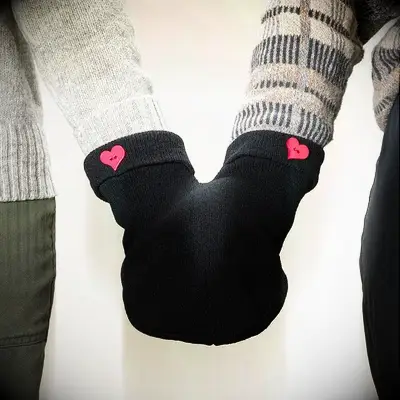 Holding hand gloves with heart buttons