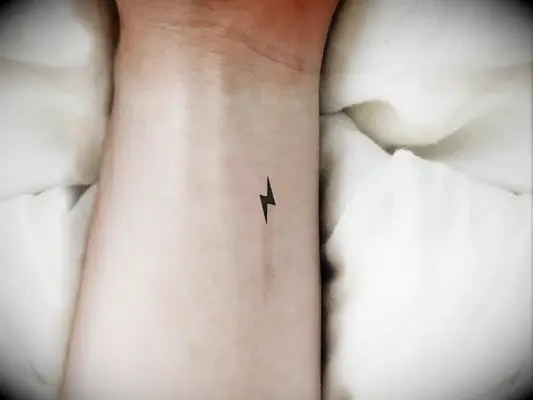 Minimalist black lightning bolt tattoo