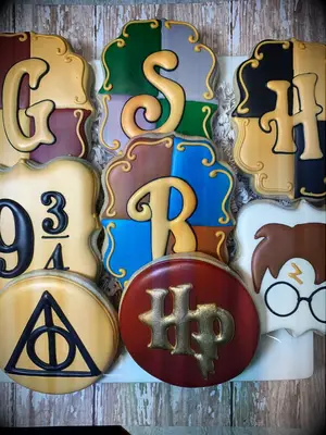 Frosted cookies with HP themed designs like Deathly Hallows symbol, Hogwarts house symbols, etc.