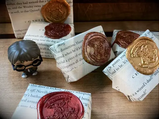 Soap bars wrapped in HP book pages with gold, bronze and rose colored Hogwarts symbol wax seals