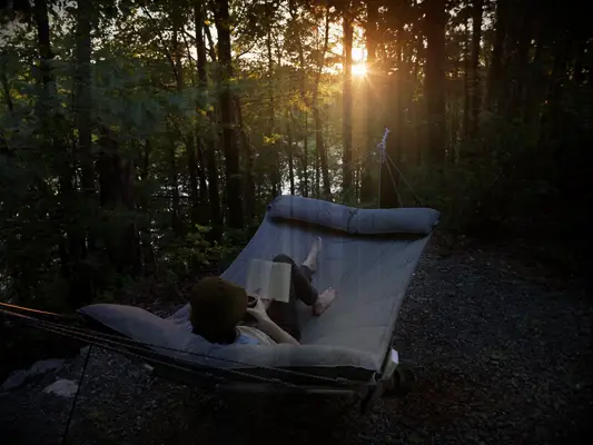 Woman relaxing reading book on hammock