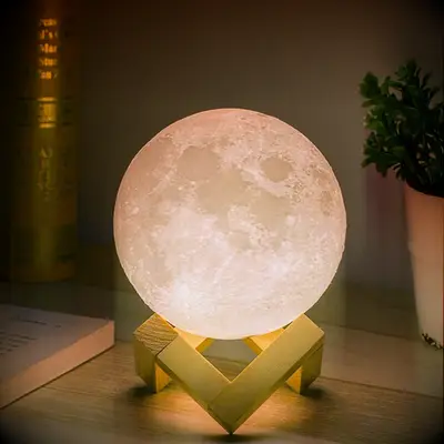 Moon shaped lamp on a geometric wood stand. 