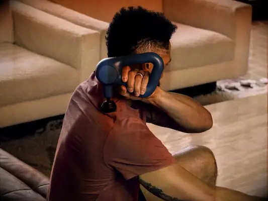 Man using handheld massage gun