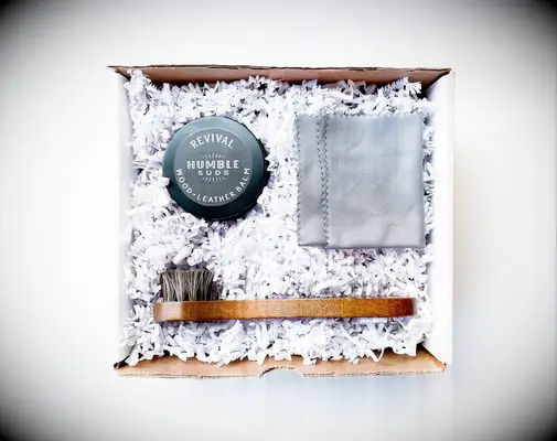 A shoe shining kit with a cloth, brush and wood-leather balm from Etsy