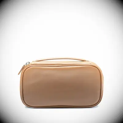 A brown leather travel bag with a short strap over the zip from Leatherology