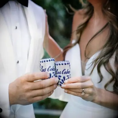 Happy couple using their personalized shot glasses on their big day