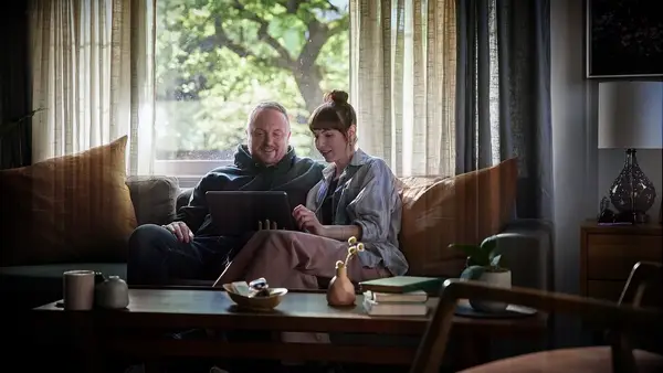 Couple on a couch watching MasterClass anniversary gift for husband