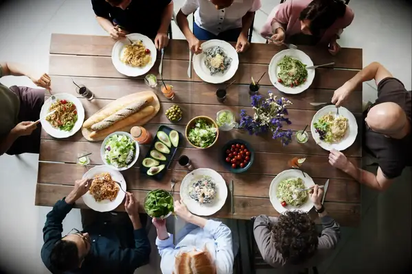 Group sharing a meal around a table 10 year anniversary gift