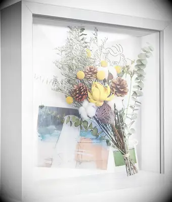 Shadow box frame storing dried bouquet and pictures for DIY anniversary gift