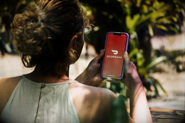 Woman looks at Doordash app on her phone thank-you gift