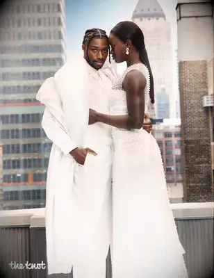 Noah Lyles and Junelle Bromfield the knot magazine cover summer 2025 issue, noah and junelle in front of cityscape