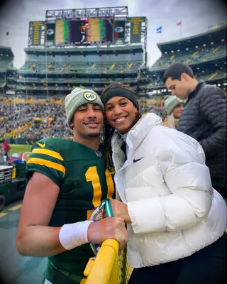 QB Jordan Love and his fiancee Ronika Stone smiling together at Packers game