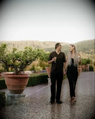 Green Bay Packers Quarterback Jordan Love and his fianceé Ronika Stone holding hands and smiling at vineyard