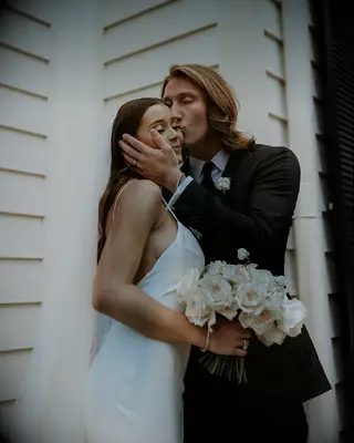 Trevor Lawrence kissing wife Marissa on cheek on wedding day