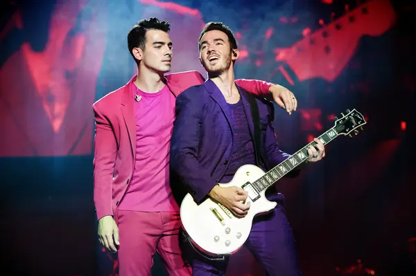 Joe Jonas shows off his wedding ring while performing. 