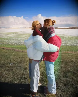 Hayley Kiyoko and Becca Tilley embracing in a snowy field