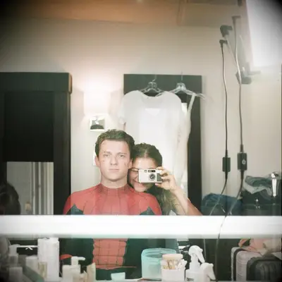 Zendaya and Tom Holland taking a mirror selfie together with a camera