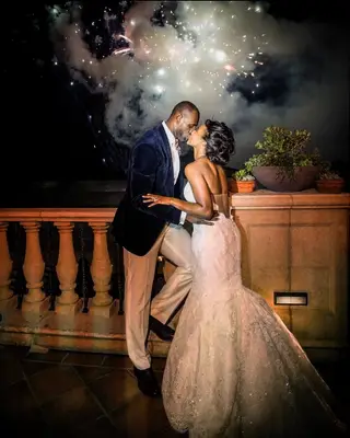 Savannah and LeBron James on wedding day kissing in front of fireworks