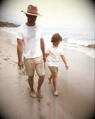 Walton Goggins and son Augustus Goggins walking on beach
