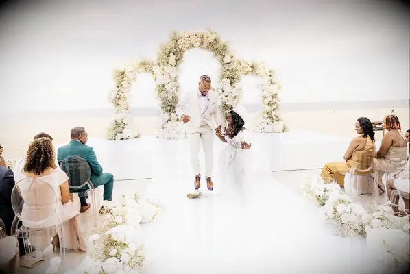 Simone Biles and Jonathan Owens jumping the broom during wedding