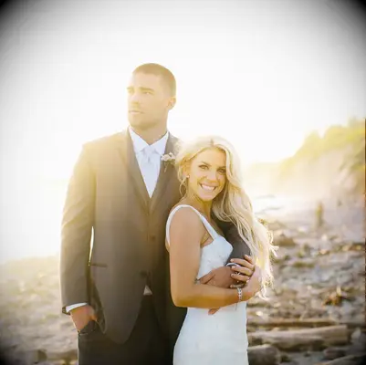 Zach and Julie Ertz posing on the beach in their wedding attire