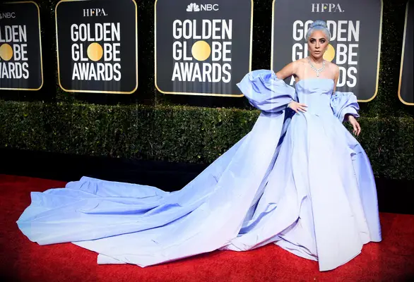 Lady Gaga wears a blue gown on the red carpet. 