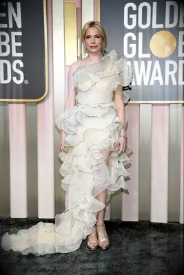 Michelle Williams wears a ruffled dress on red carpet. 