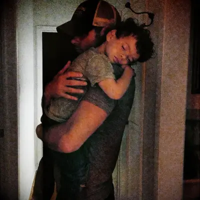 Mikey Day holding son