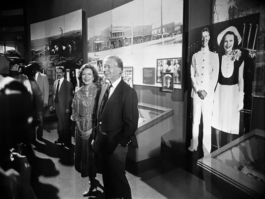 Rosalyn and Jimmy Carter standing in front of their wedding portrait