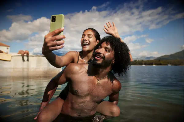 Woman taking selfie with friend during vacation