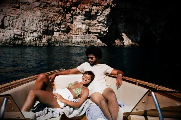 Woman resting by boyfriend sitting in motorboat