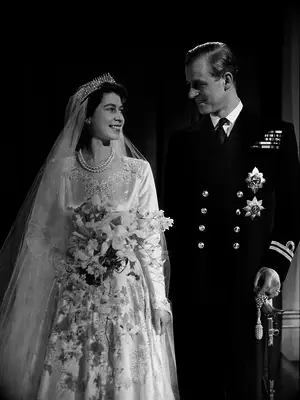 Queen Elizabeth and Prince Phillip wedding portrait showing off wedding dress and flower bouquet