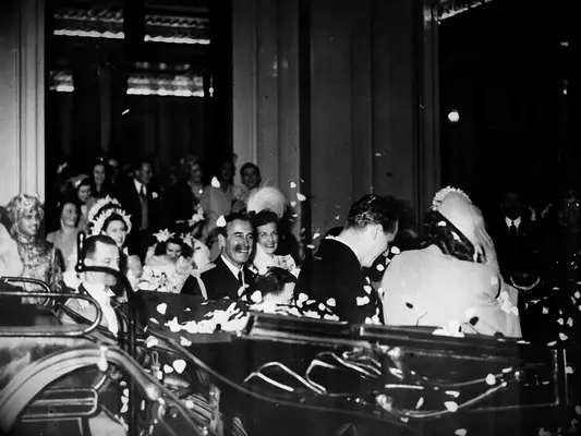 Queen Elizabeth leaving wedding in a blue going away outfit with Prince Phillip in a carriage