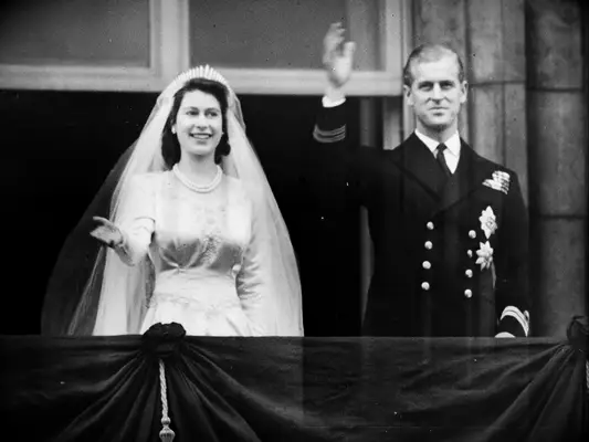 Queen Elizabeth and Prince Phillip waving from balcony of Buckingham Palace on wedding day