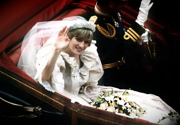 Princess Diana wears a modern fringe tiara and waves at the camera. 