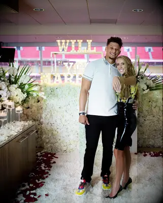 Brittany and Patrick smile at the camera at the scene of a romantic proposal. 