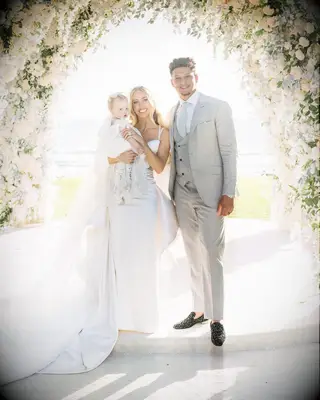 Brittany, Patrick, and their daughter pose for the camera on their wedding day. 