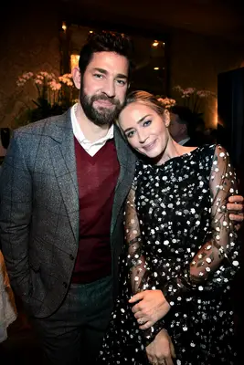 John Krasinki and Emily Blunt smile at a formal event. 