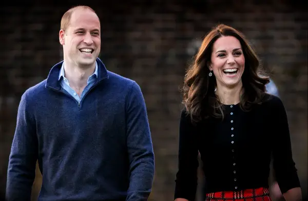Kate Middleton and Prince William smile at the camera. 
