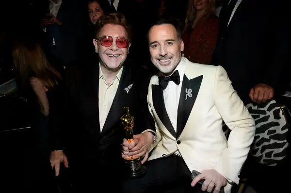 Elton John and David Furnish smile at the Oscars. 
