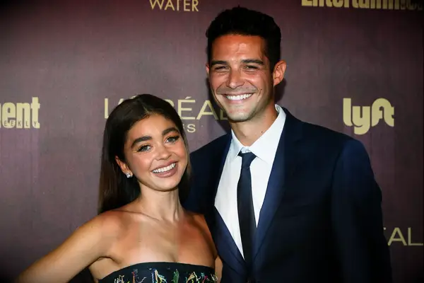 Sarah Hyland and Wells Adams smile on the red carpet. 