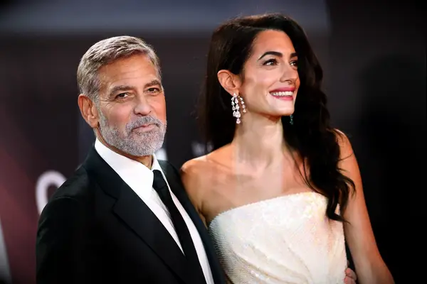 George and Amal Clooney smile for the camera. 