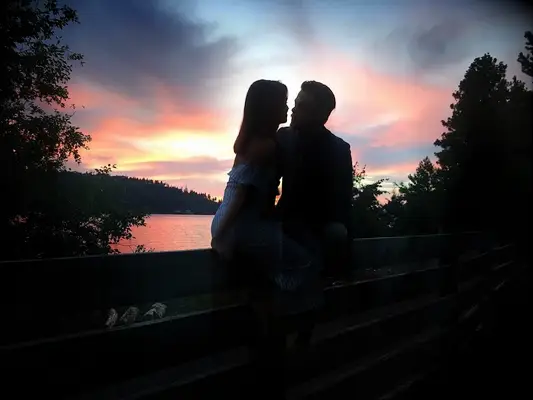Couple sitting together with sunset behind