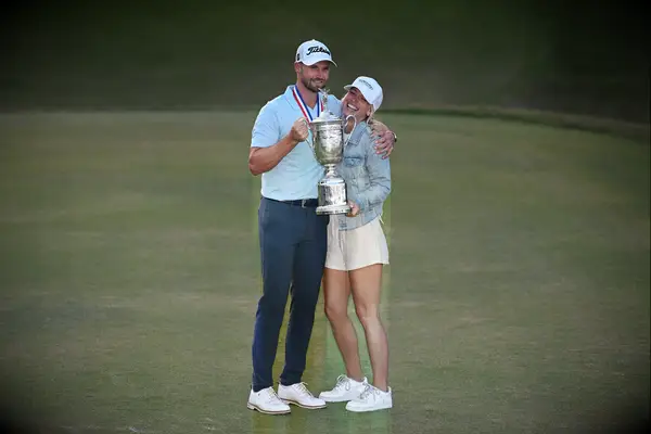  Wyndham Clark and Alicia Bogdanski smiling and holding a trophy
