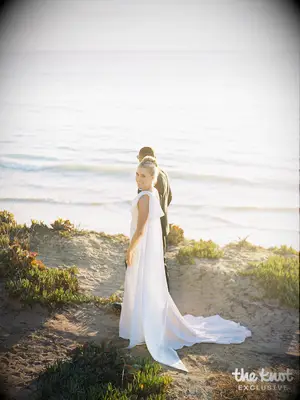 Michael Norman with his wife Jenna posing for wedding photos on the beach