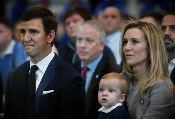 Eli Manning of the New York Giants looks on with his wife, Abby, and son, Charles, during a press conference to announce his retirement