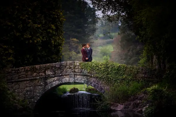 Tom and his husband standing on a bridge on their wedding day