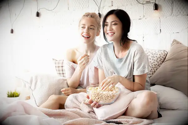 Friends eating popcorn and watching a movie